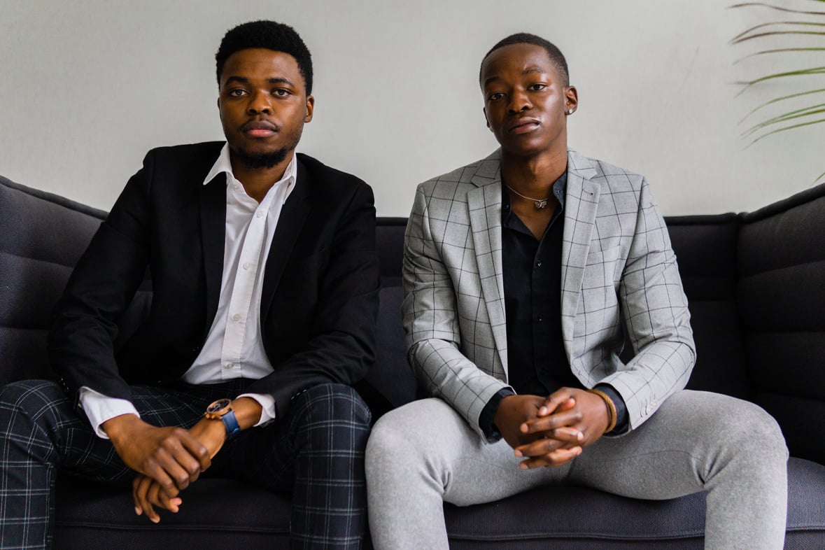 Men in Suit Jacket Sitting on Gray Couch